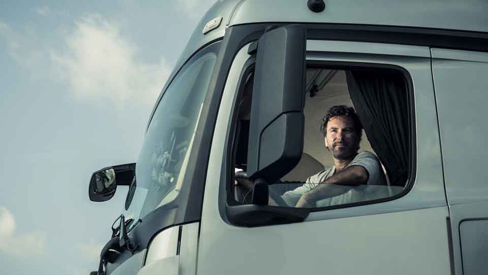 Paketkurier sitzt im Wagen